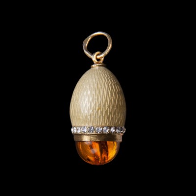 Zawieszka jajko Faberge zdobiona kremową emalią. Srebro złocone, cyrkonie i bursztyn. 